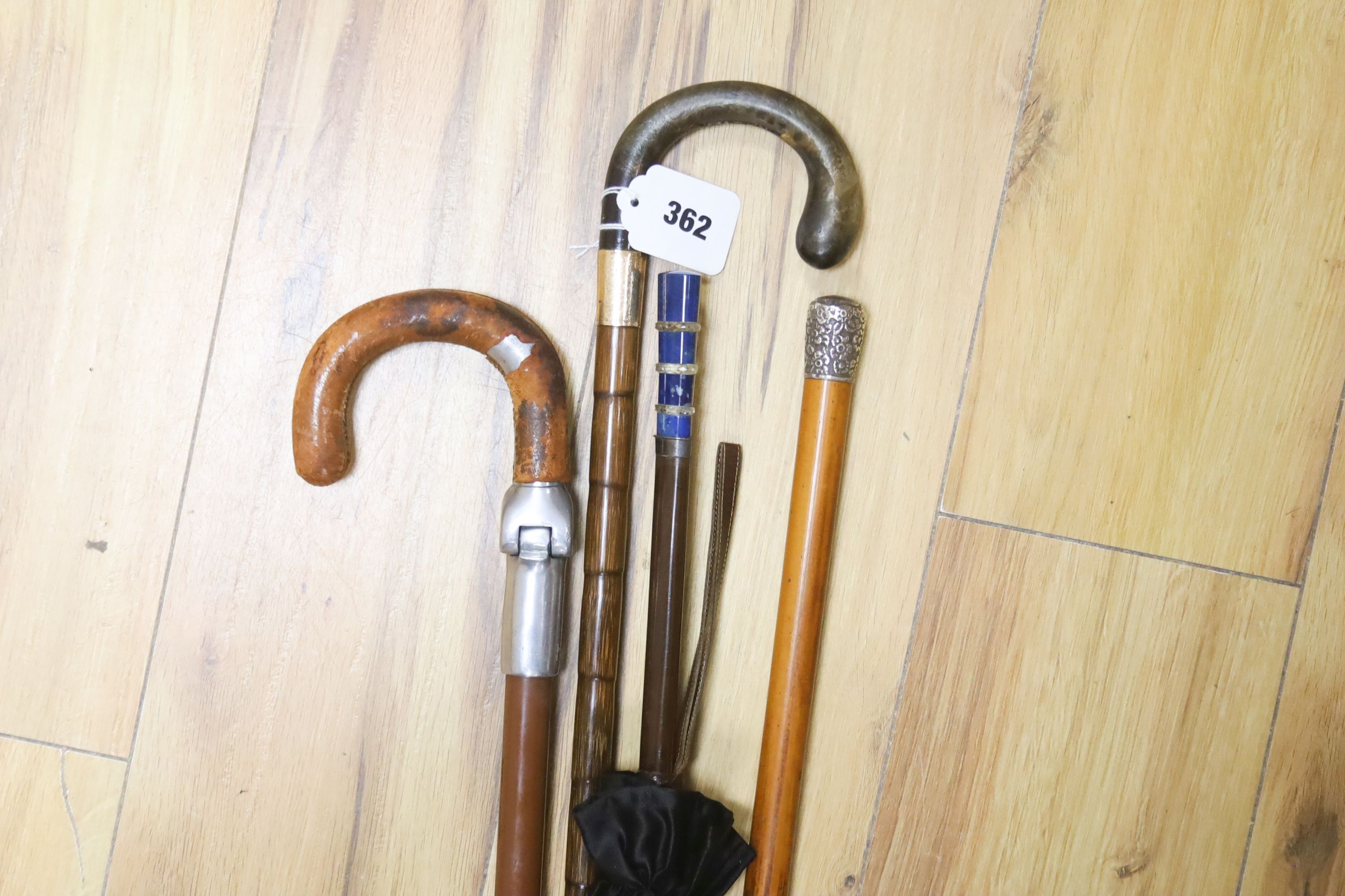 A Victorian 9ct gold mounted walking stick, parasol, silver-mounted stick, etc